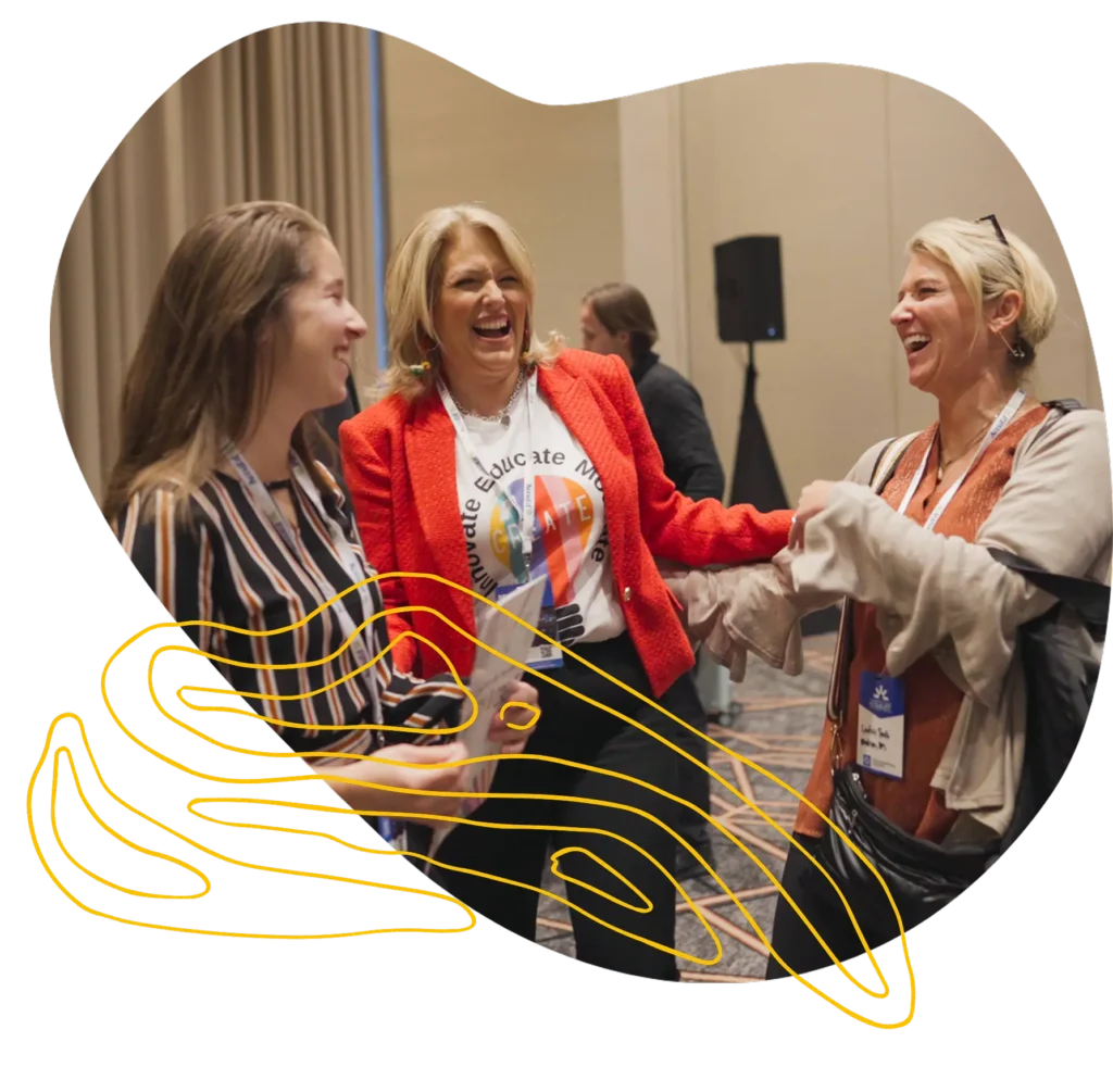Three women smiling and chatting during a networking session at a professional conference